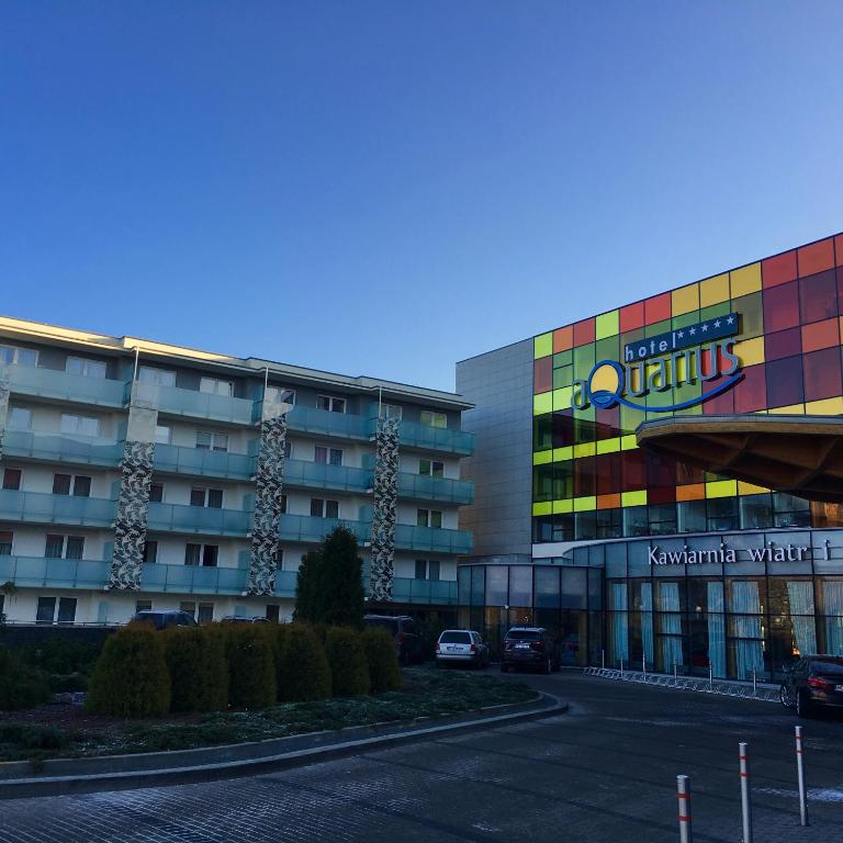 a large building with a parking lot in front of it at AquaBaltic Apartments Aquarius in Kołobrzeg