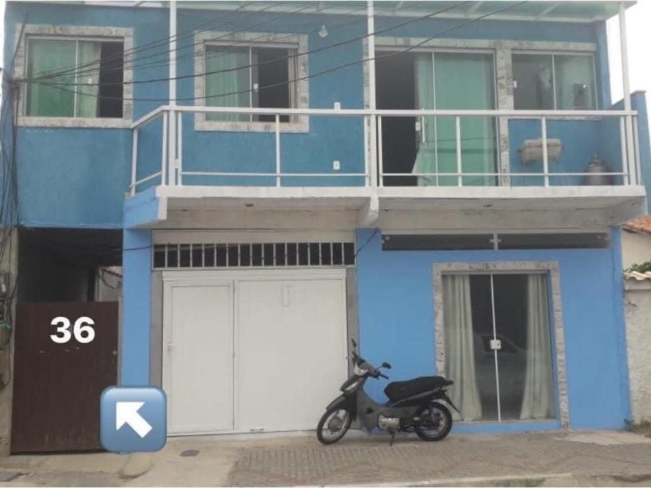 a motorcycle parked in front of a blue building at Flats Mirassol in Arraial do Cabo