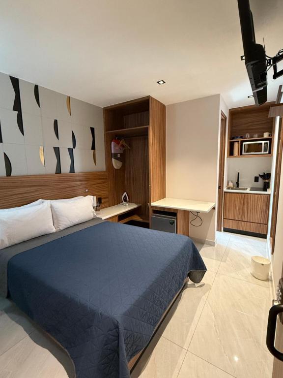 een slaapkamer met een blauw bed en een keuken bij Pánuco Suites in Mexico-Stad