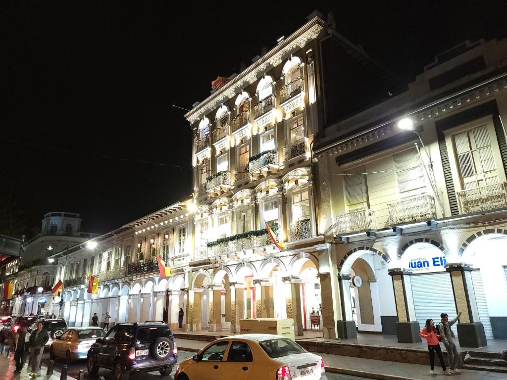 a building with cars parked on a street at night at Casa Centro Histórico Cuenca in Cuenca