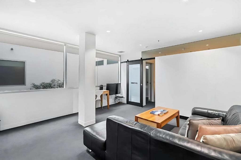 a living room with a couch and a table at Gibson Mill waterfront warehouse apartment - 204 in Hobart