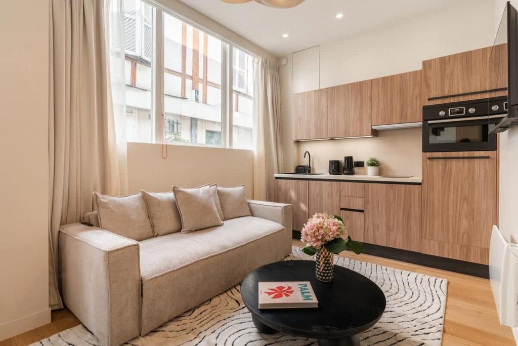 un salon avec un canapé et une table dans l'établissement Splendide appartement de luxe Saint-Germain, à Paris