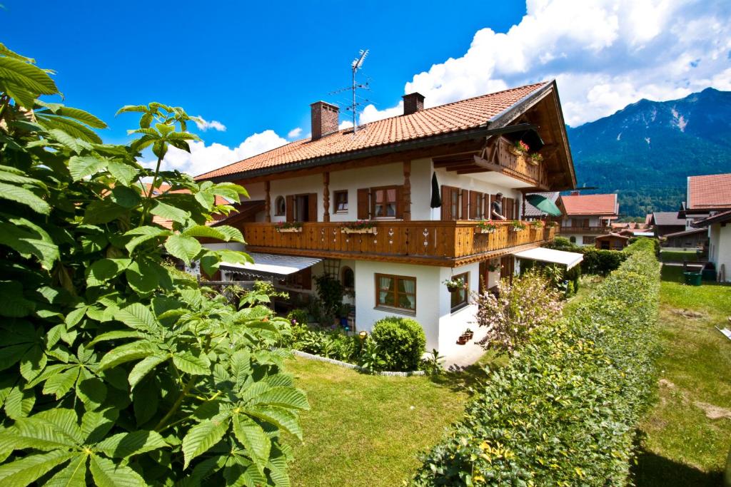 una casa en una colina con montañas en el fondo en Ferienhaus Andreas, en Krün