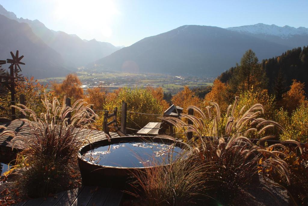una bañera de hidromasaje en un jardín con montañas al fondo en Panoramablick Osttirol, en Lienz