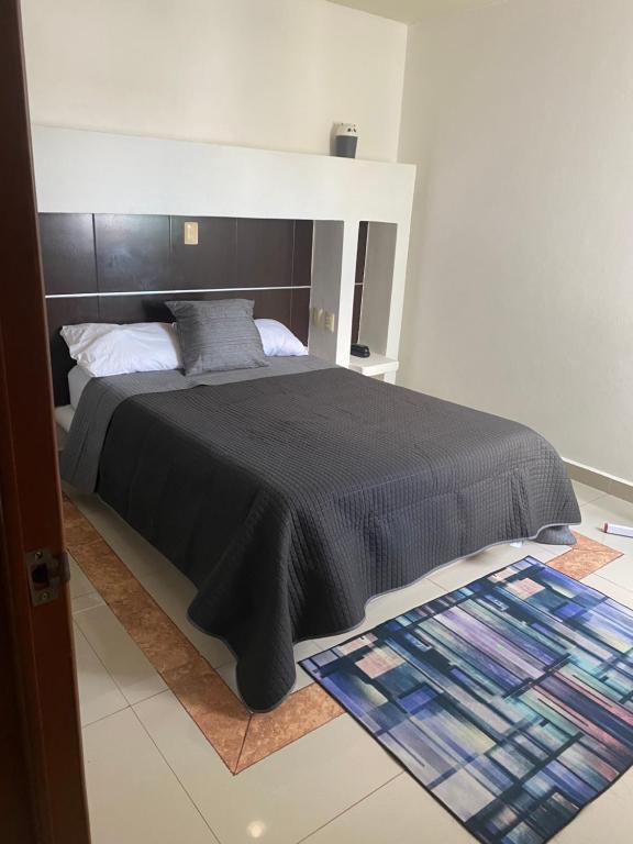 een slaapkamer met een groot bed en een zwarte deken bij SUIT HOME EXPRESs in Cancun