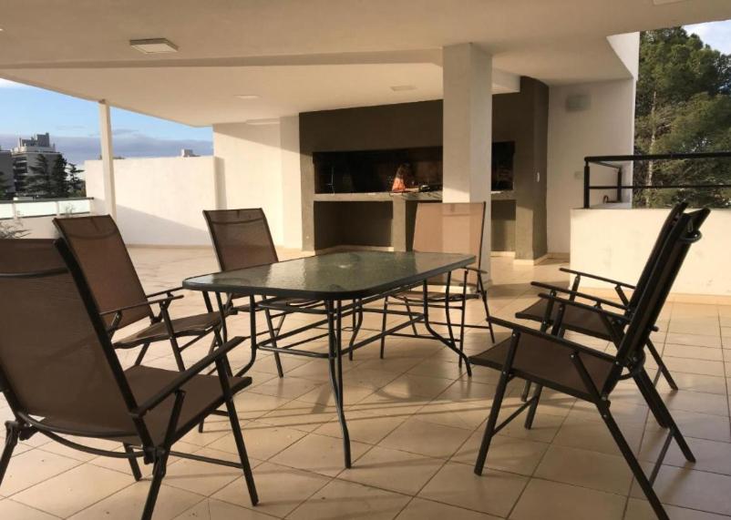 a glass table and chairs on a patio at Depto Centrico Exclusivo in Villa Carlos Paz