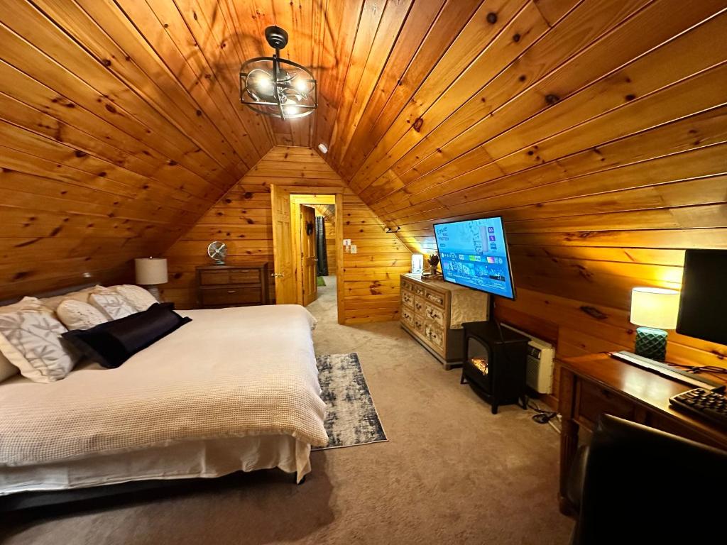 a bedroom in a log cabin with a bed and a television at Cozy Cabin in Red River Gorge in Rogers