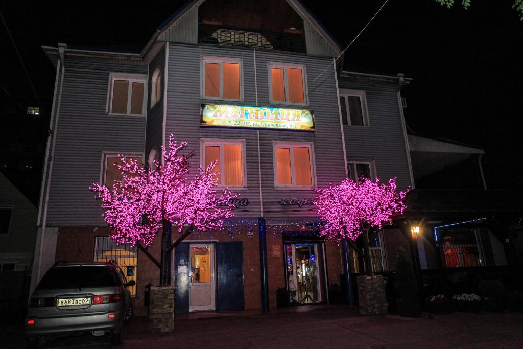 a building with pink trees in front of it at Hotel "Magnoliya" in Tuapse