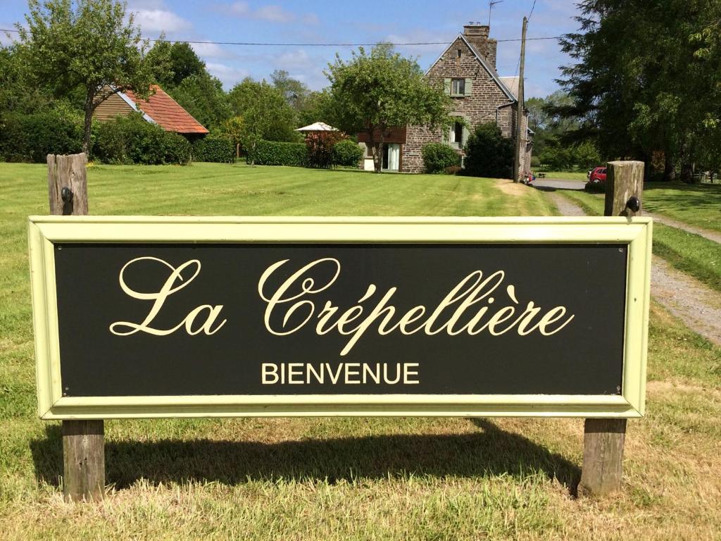 una señal frente a una casa con un patio en La Crepelliere, en Villedieu-les-Poëles