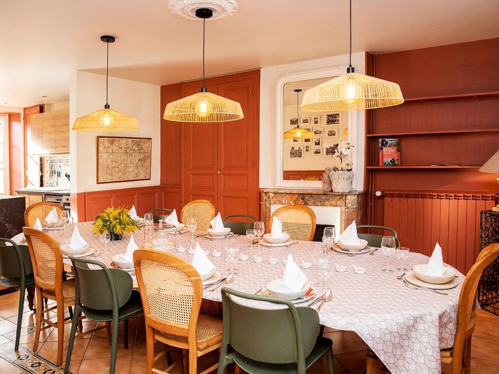ein Esszimmer mit einem Tisch, Stühlen und Lampen in der Unterkunft Charmante maison berrichonne avec terrasse et WIFI proche Châteauroux - FR-1-591-710 in Déols