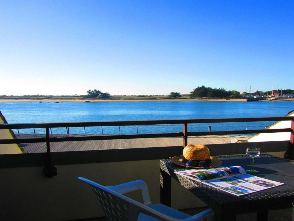 une table et des chaises sur un balcon avec vue sur l'eau dans l'établissement Studio à Étel - 2* - Proche plage, animaux admis - FR-1-479-168, à Étel