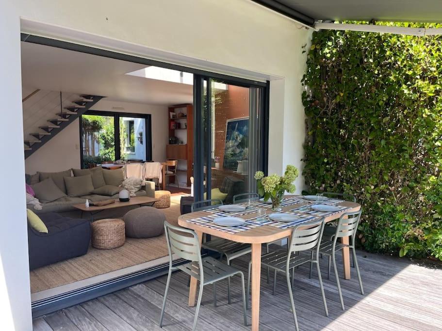 une table à manger et des chaises dans un salon dans l'établissement Maison contemporaine 6 couchages, 50m de la plage, à La Trinité-sur-Mer