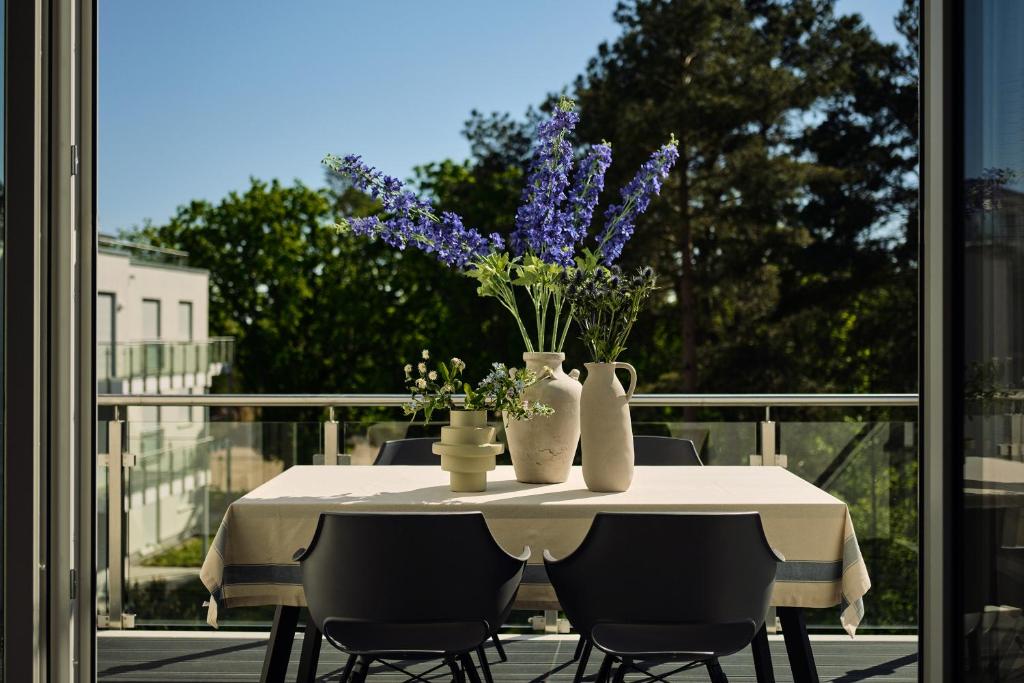 a table with vases and flowers on a balcony at Maisonette-Apartment C11 Zwei Balkone, zwei Terrassen im "Pine Hill Resort" in Zirchow