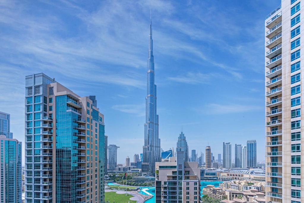 a view of a city skyline with a tall skyscraper at Savis Homes - Luxury 2 Bedroom Suite with Full Burj Khalifa View in Dubai