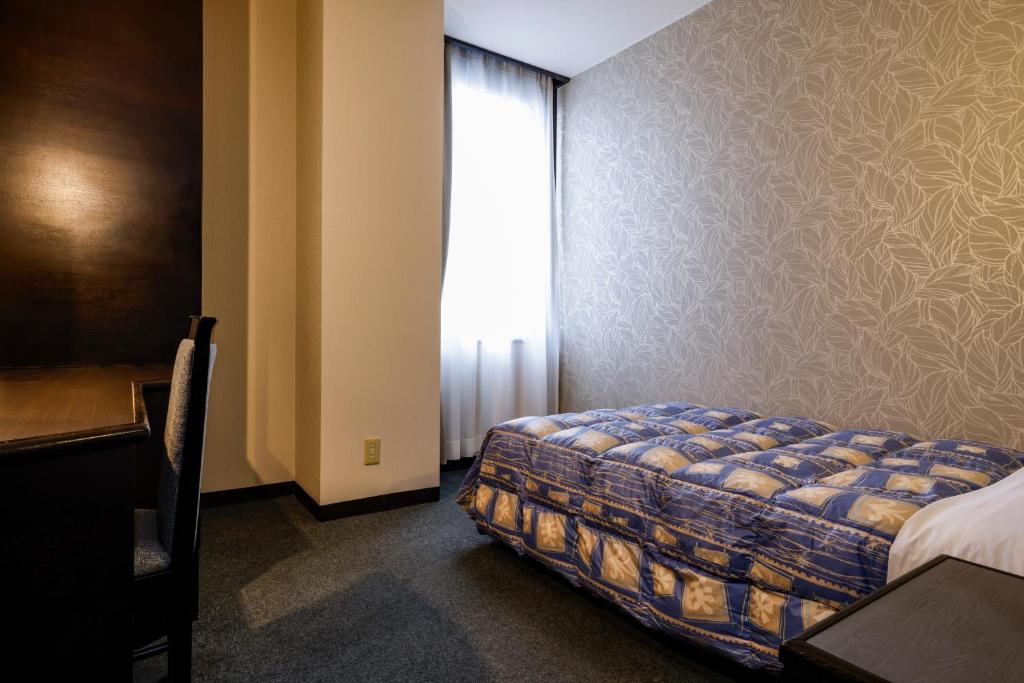 Postel nebo postele na pokoji v ubytování Kotohira Riverside Hotel