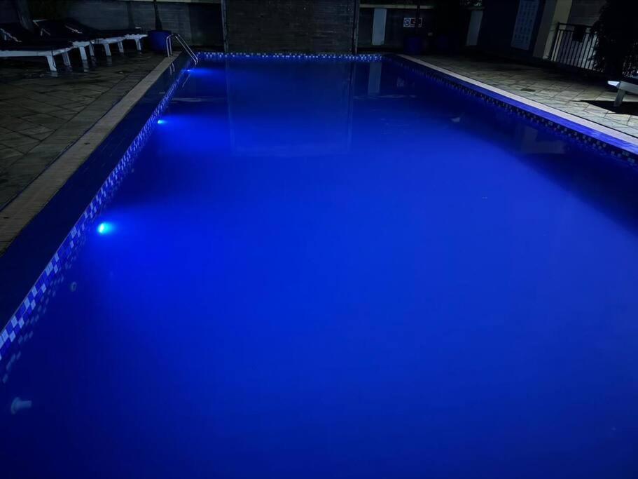 a swimming pool with blue lights in the dark at karibu homes, epic brownstone phase 1 in Nairobi