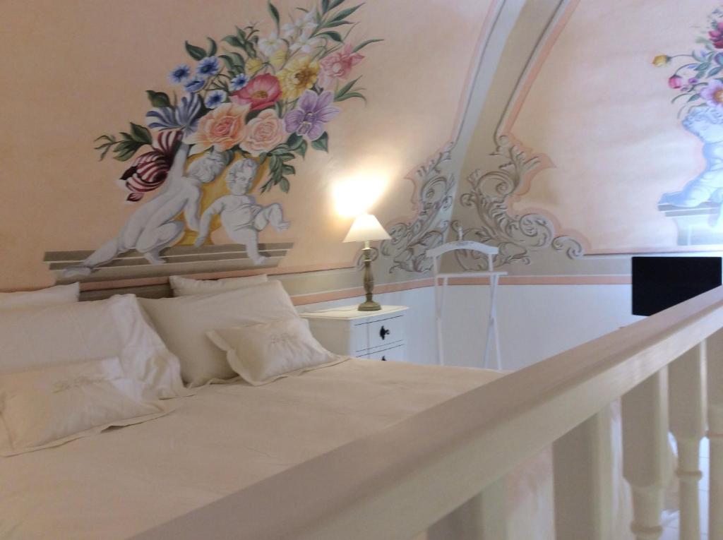 1 dormitorio con 1 cama con una pintura en la pared en Suite Le Perle, en Taranto