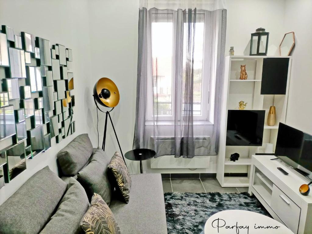 un salon avec un canapé et une télévision dans l'établissement Agréable et moderne 2 pièces ~ confort et design, à Clermont-Ferrand
