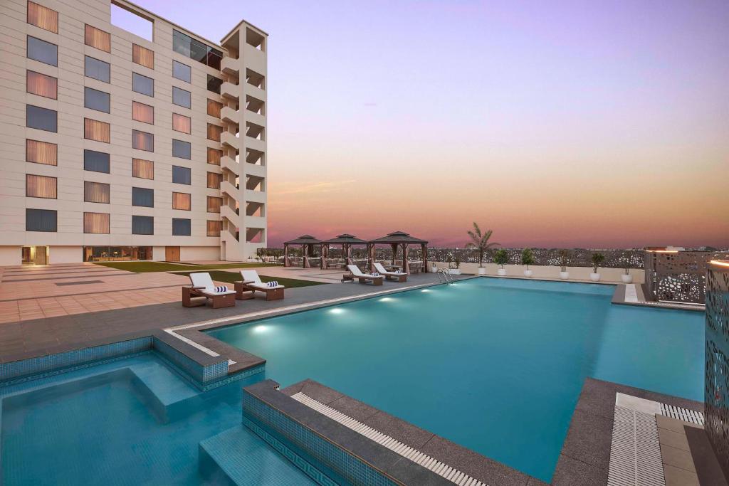 a swimming pool in front of a hotel at Doubletree By Hilton Varanasi in Varanasi
