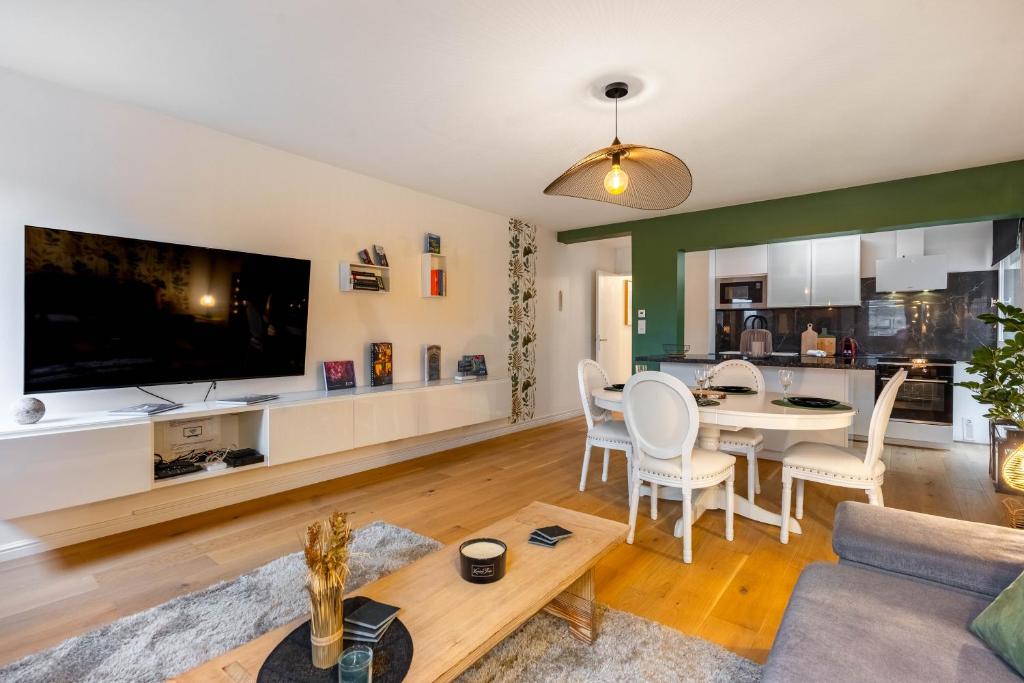 - un salon avec une grande télévision et une table dans l'établissement Le précieux de Raoul Nancy centre avec ascenseur, à Nancy