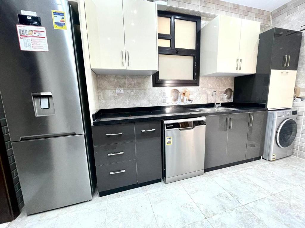 a kitchen with a stainless steel refrigerator and a dishwasher at كمبوند مفيدا in New cairo