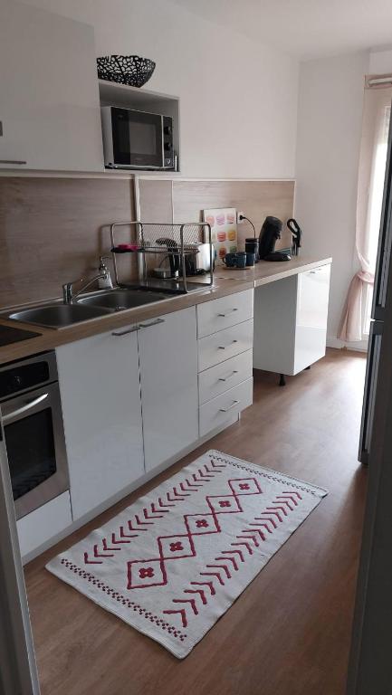 - une cuisine avec un tapis de base-ball au sol dans l'établissement cosy pres de la cepiere, à Toulouse