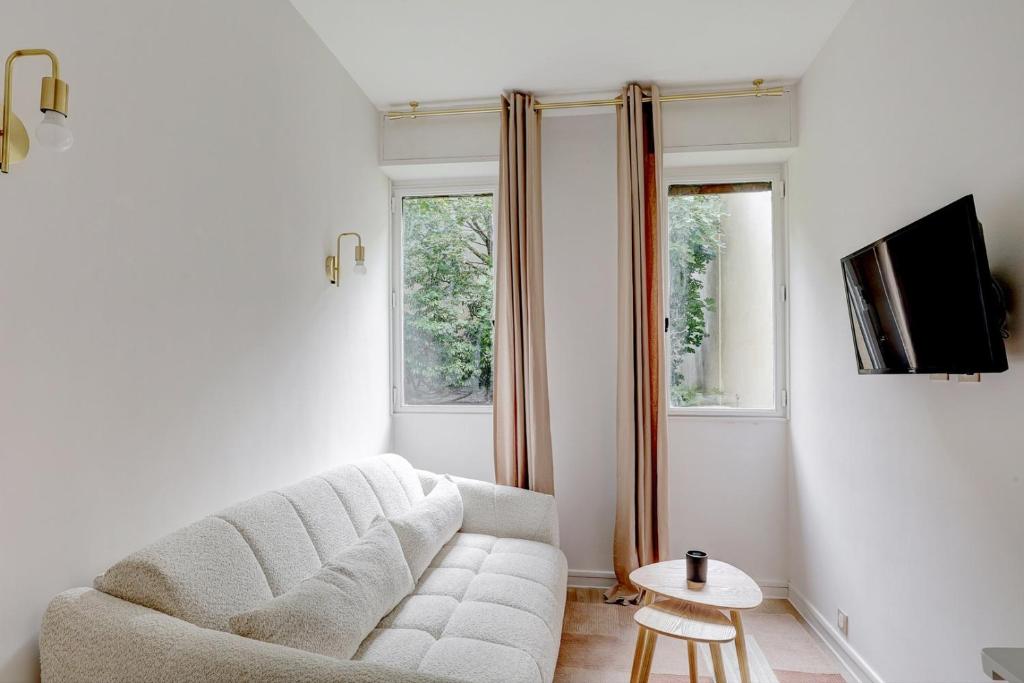un salon avec un canapé et une télévision dans l'établissement Bluestay 806 - Superb studio, à Paris