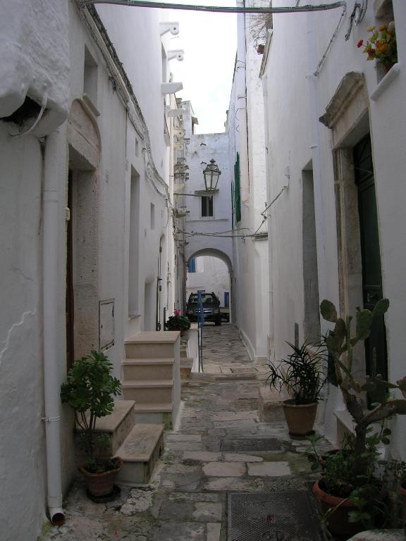 an alley with an archway in a white building at Casa Vacanze Cattedrale in Ostuni