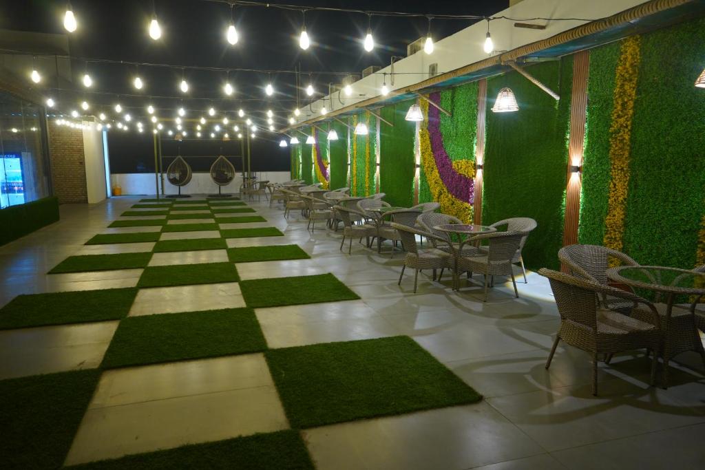 a room with a green wall with tables and chairs at OVEL Hotel & RESORT in Ludhiana
