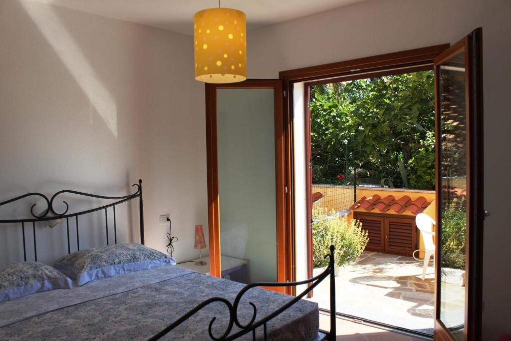 ポザーダにあるDimora Shardanaのベッドルーム1室(ベッド1台付)、スライド式ガラスドアが備わります。