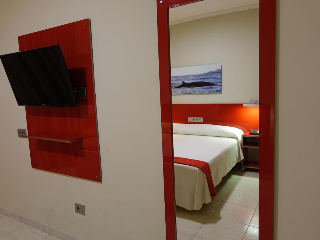 a bedroom with a bed with a mirror and a tv at Hotel Andrea´s in Los Cristianos