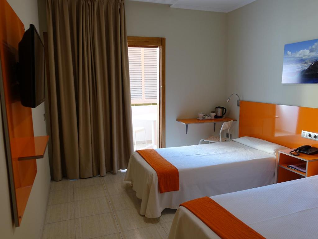 a hotel room with two beds and a window at Hotel Andrea´s in Los Cristianos