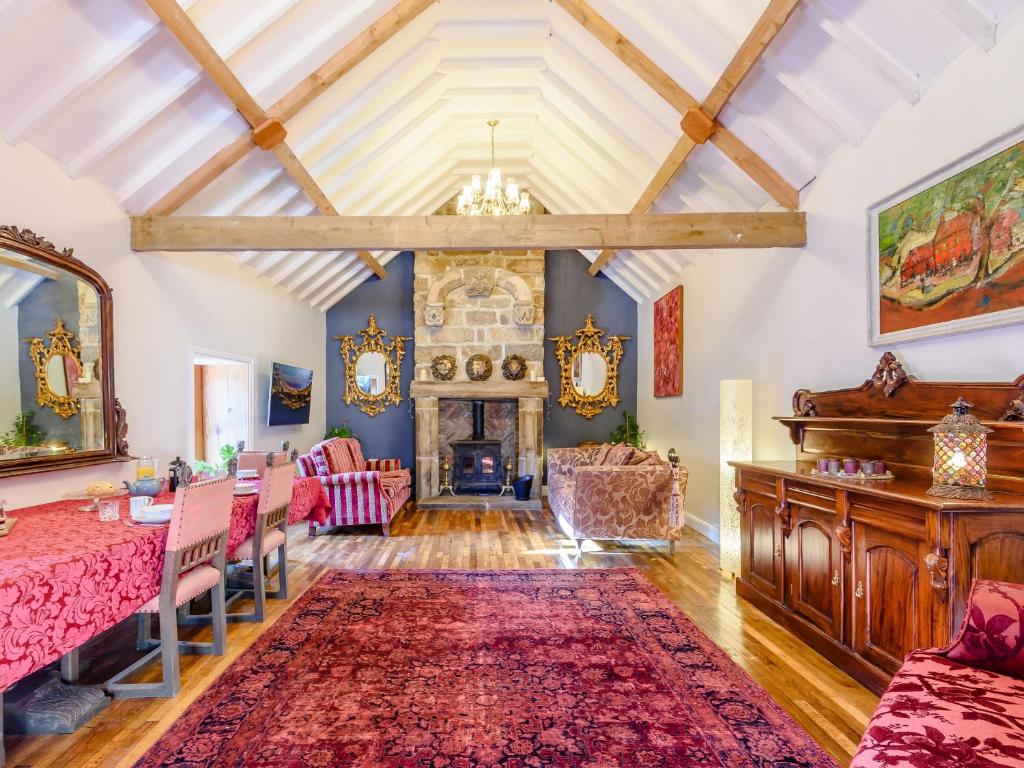 a living room with a table and a fireplace at Lady De Seton - Uk31956 in Staithes