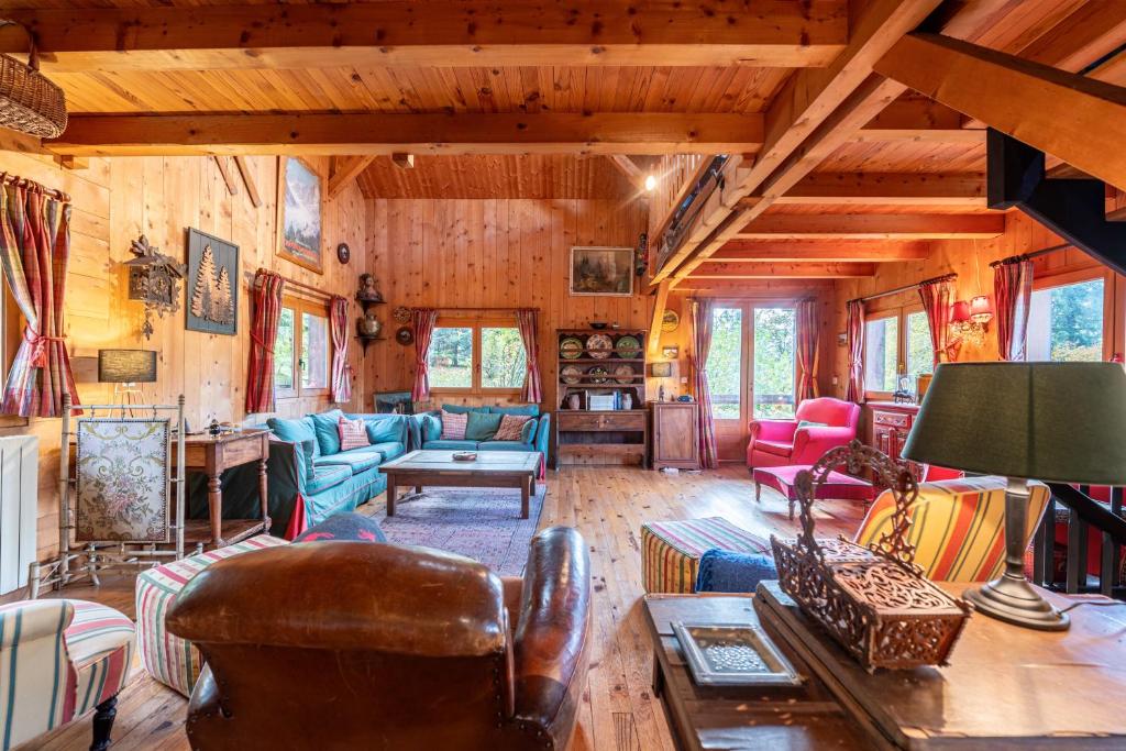 un soggiorno con pareti e mobili in legno in una cabina di Le Chavot - Chalet 140 m² pour 8 personnes a Cohennoz