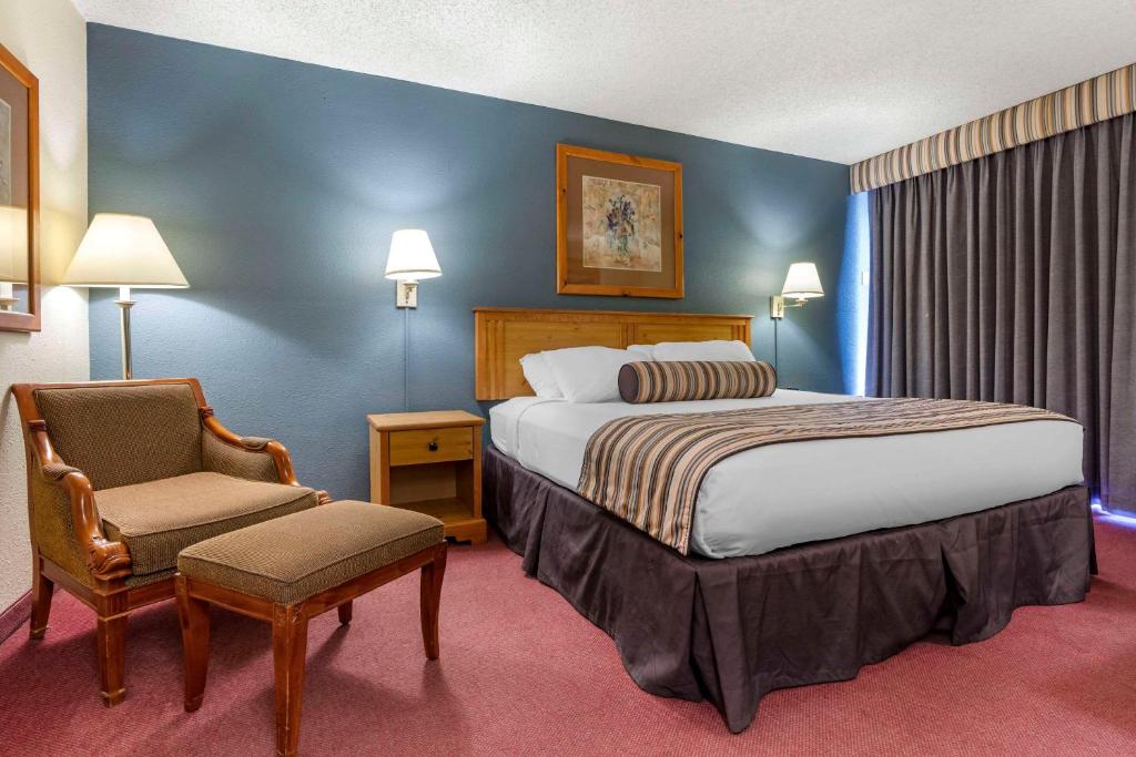 ein Hotelzimmer mit einem Bett und einem Stuhl in der Unterkunft The Federal Hotel Downtown Carson City, Ascend Hotel Collection in Carson City