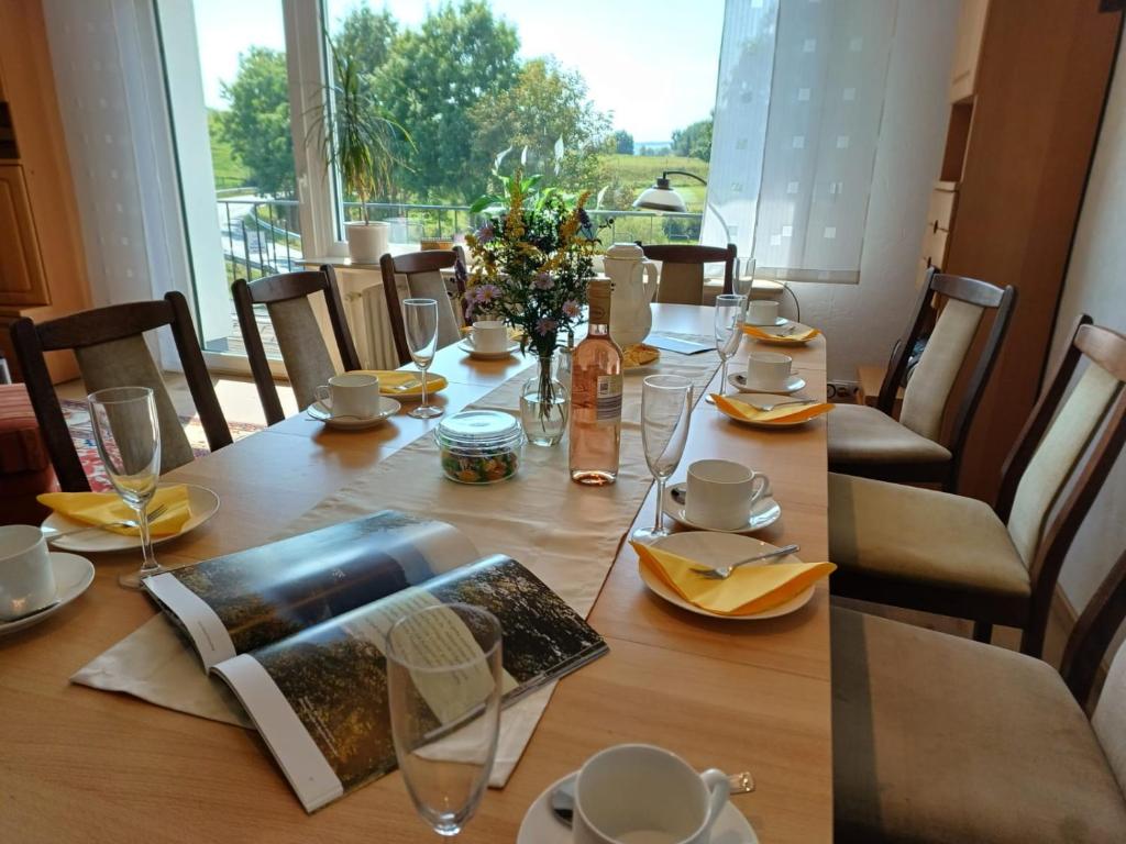 a dining room table with chairs and a large window at Ferienhaus Birkelbach in Erndtebrück