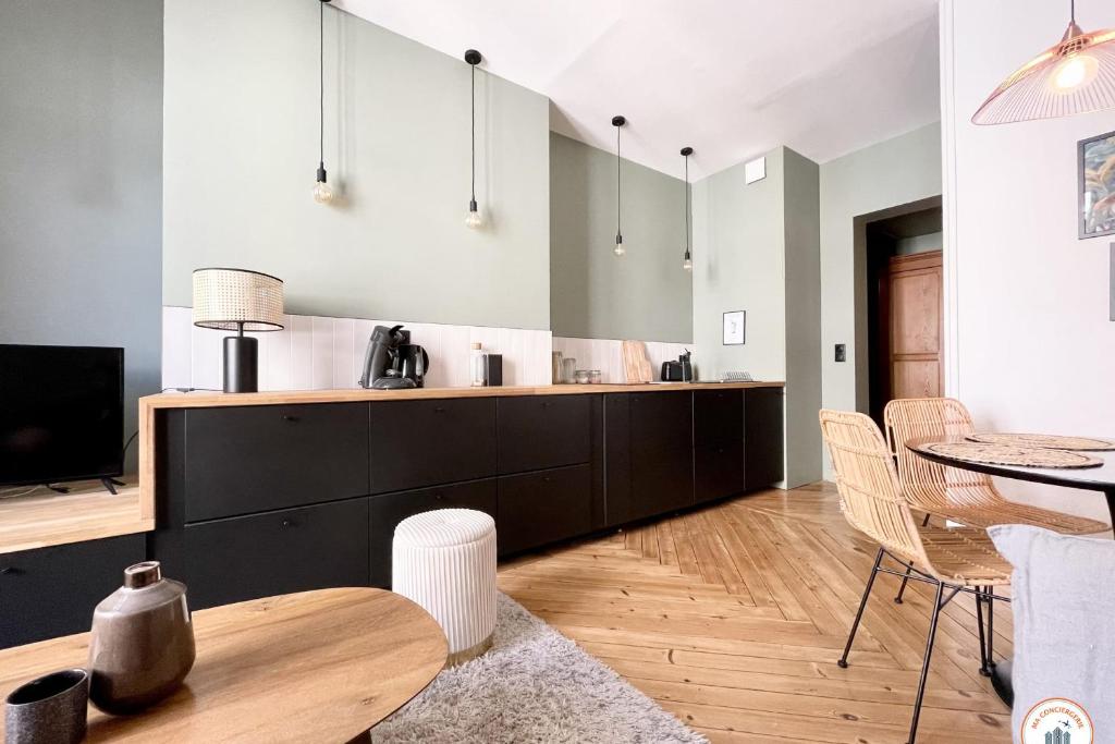 une cuisine et une salle à manger avec une table et des chaises dans l'établissement l'Exotique - Vue Pl Vieux Marché - Standing, à Rouen
