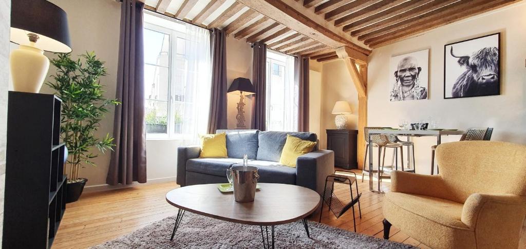 un salon avec un canapé et une table dans l'établissement Place St Sauveur - Standing et Confort, à Caen