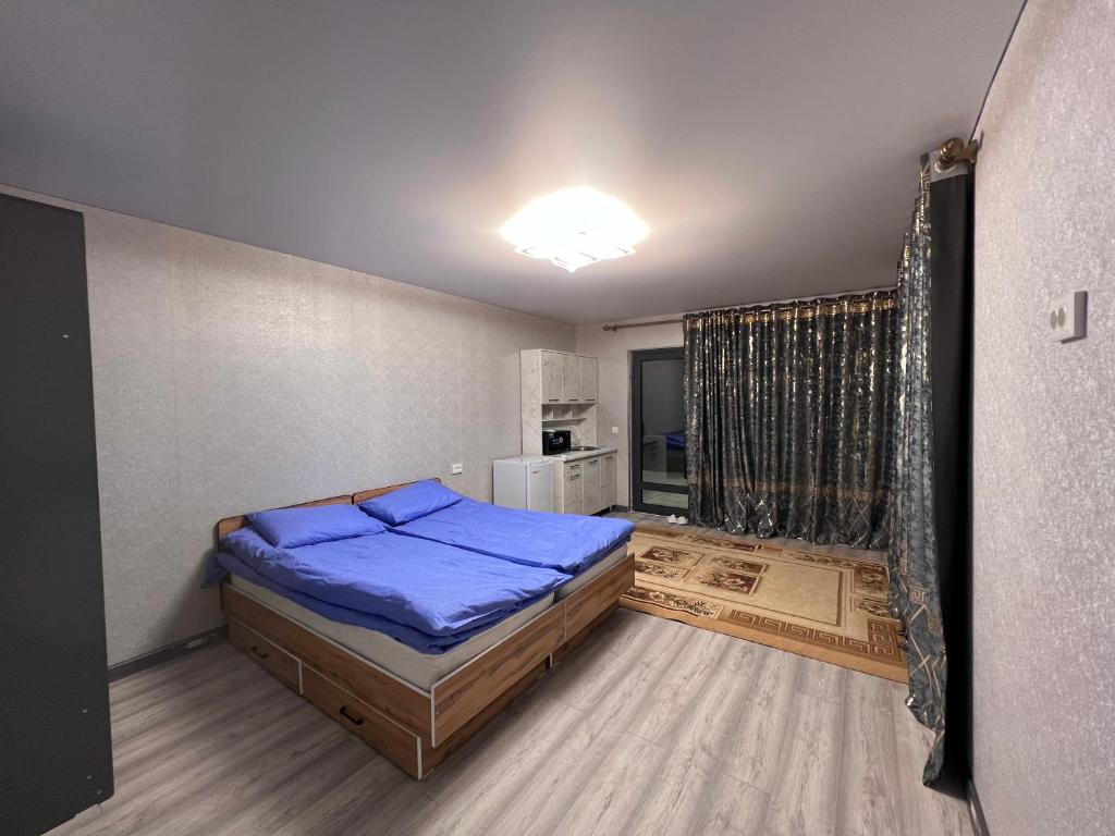 - une chambre avec un lit bleu dans l'établissement Tims cottage, à Karakol
