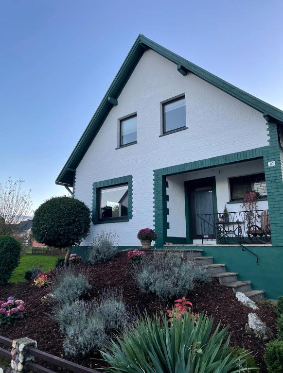 a green and white house with a garden at Landhaus "Marcomagus" in Kall