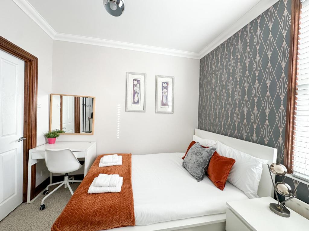 伦敦Fulham Rooms的一间带床和书桌的白色卧室