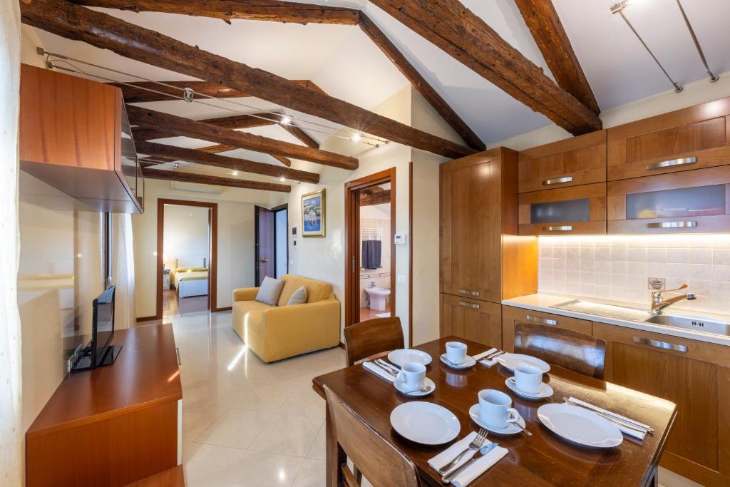 Una cocina y una sala de estar con una mesa y sillas de madera. en Residenza San Piero, en Venecia