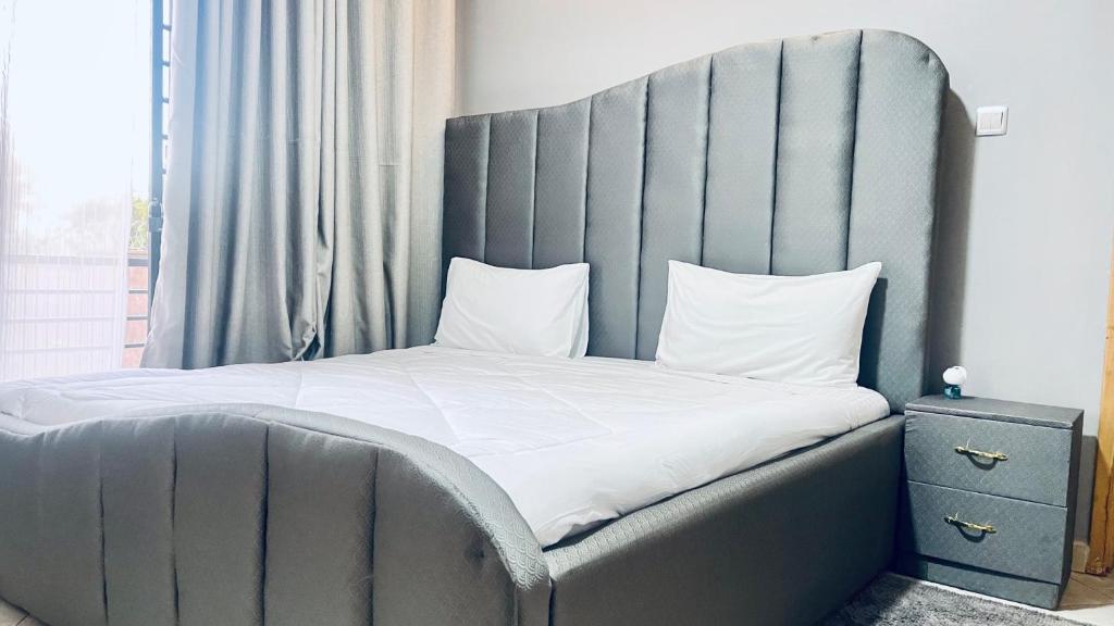 a bed with a large headboard in a bedroom at Lake View Muyenga Apartment in Kampala