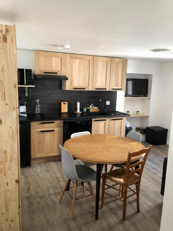 une cuisine avec une table et des chaises dans une pièce dans l'établissement Petit cocon géromois, à Gérardmer