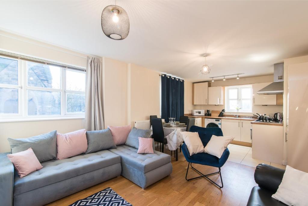 ein Wohnzimmer mit Couch und Küche in der Unterkunft Derby Dream 2 Bed Apartment - Close to City Center in Derby