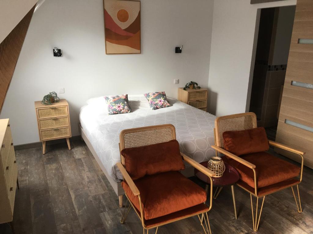 una camera con un letto bianco e due sedie di La marine D'opale ad Ambleteuse