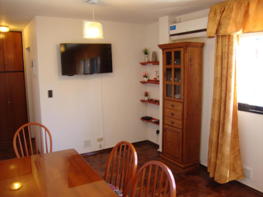 uma sala de jantar com uma mesa e cadeiras e uma televisão em Departamento Maipu Cordoba em Córdova