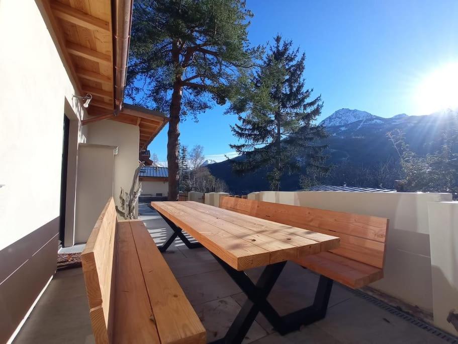 un banc en bois posé au sommet d'un balcon dans l'établissement Maison La Boneca, à Saint-Chaffrey