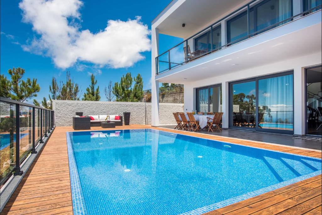 einen Pool in einer Villa mit einem Haus in der Unterkunft Villa Enjoy - by LovelyStay in Lombo da Velha
