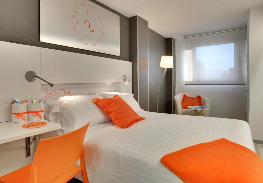 
a hotel room with two beds and a lamp at Hotel Bed4U Pamplona in Cordovilla
